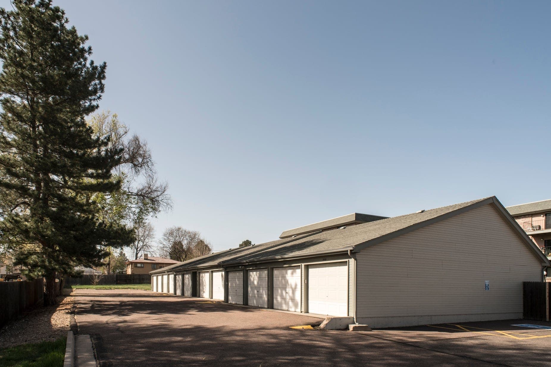 A long row of private garages with individual up-and-over doors, each opening onto the community’s own driveway.